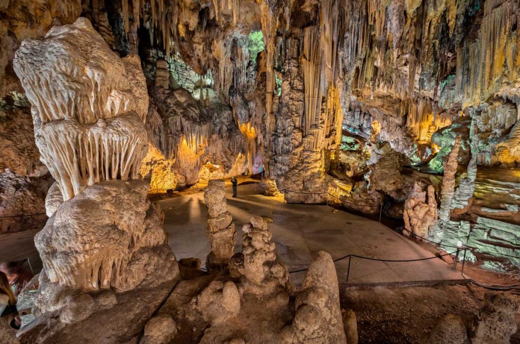 Cueva de Nerja, Spain – A vast underground cavern adorned with dramatic stalactites and stalagmites, illuminated by warm lighting. This prehistoric cave is a natural wonder on the Costa del Sol.