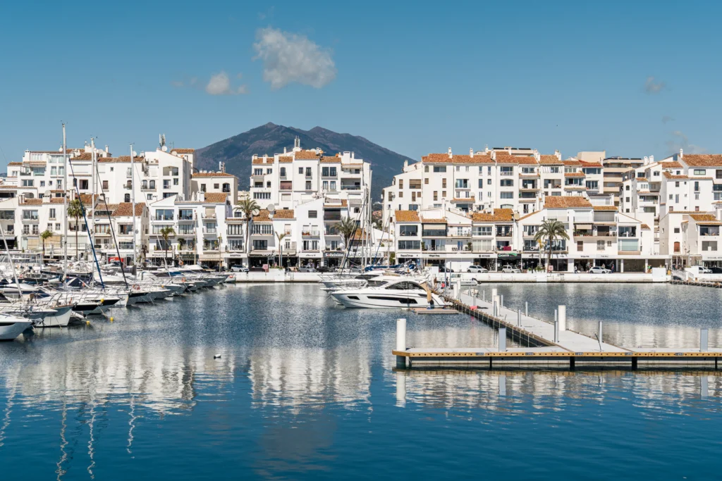 Puerto Banús, Marbella – A world-renowned marina with luxury yachts, white Mediterranean-style buildings, and mountain views in the background. An iconic destination on the Costa del Sol, known for its exclusive lifestyle and upscale atmosphere.